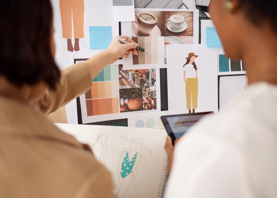 Uma mulher e um homem em frente a um painel de imagens, escolhendo um símbolo que remeta à empresa que eles representam