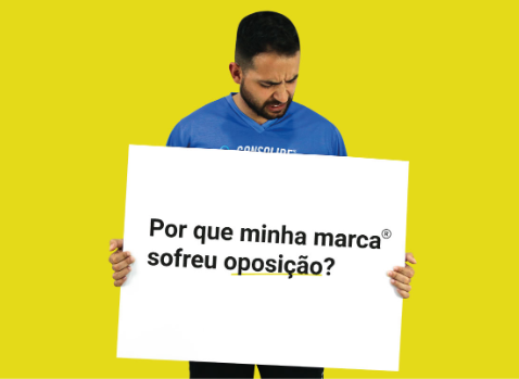 homem segurando cartaz com frase porque minha marca sofreu oposição
